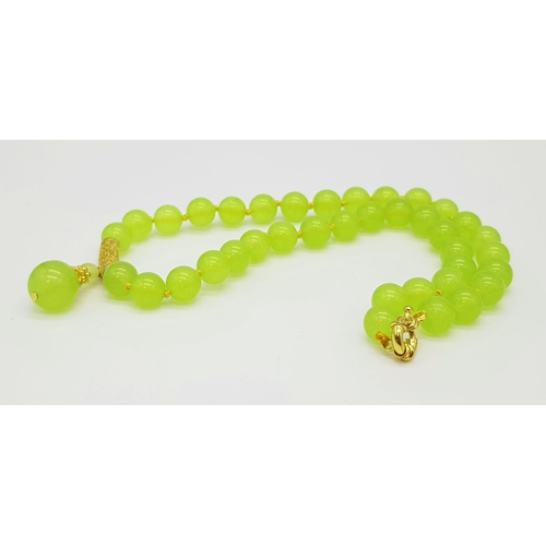 386 - A Peridot Bead Necklace with Drop Gilded Pendant and Clasp. 42cm and 3cm. Beads - 10mm