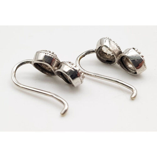 1205 - A Pair of Antique Old-Cut Rose Coloured Diamond Earrings. 
Set in white metal. 3.21g total weight.