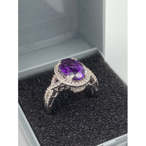 223 - Magnificent 3 carat AMETHYST SOLITAIRE set in a SILVER RING with WHITE TOPAZ surround. Size N.