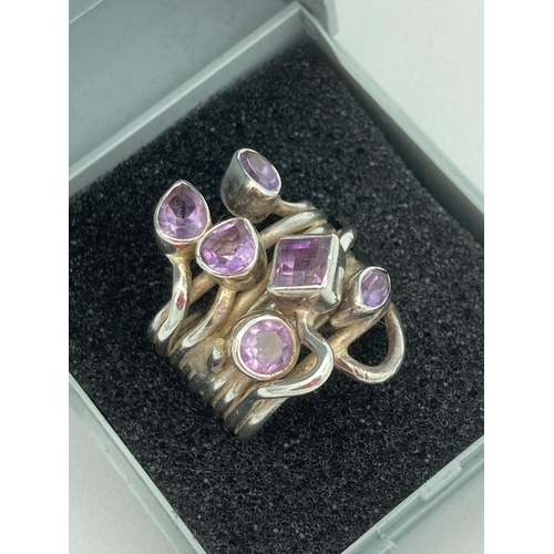 532 - SILVER and AMETHYST RING having wide SILVER coiled band set to top with Amethysts. Presented in jewe... 