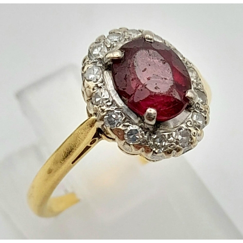 337 - A Vintage 18K Yellow Gold Ruby and Diamond Ring. Central oval ruby surrounded by a halo of diamonds ... 