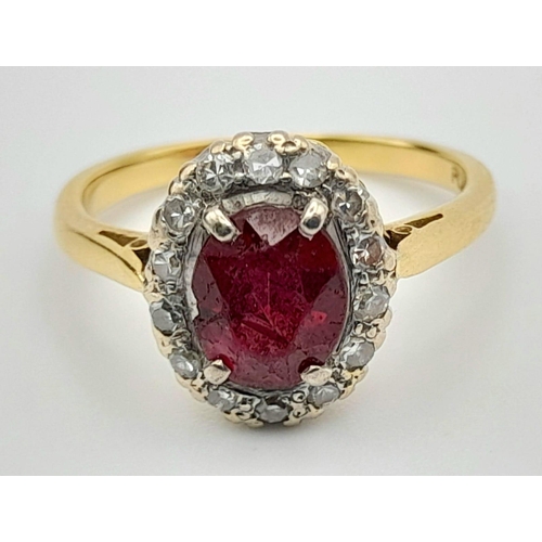 337 - A Vintage 18K Yellow Gold Ruby and Diamond Ring. Central oval ruby surrounded by a halo of diamonds ... 