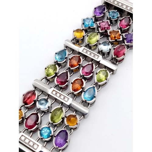 591 - A Corum Gemstone and Diamond Ladies Watch. Multi-gemstone bracelet with diamond bar separators. Case... 