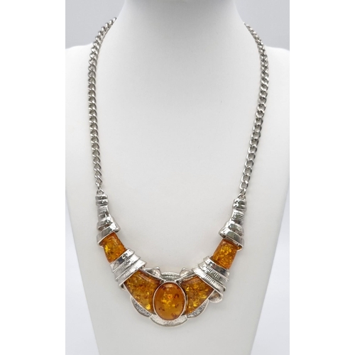 196 - An ART DECO white metal (untested) and amber necklace accompanied by an amber ring (size: N1/2). 
Ne... 