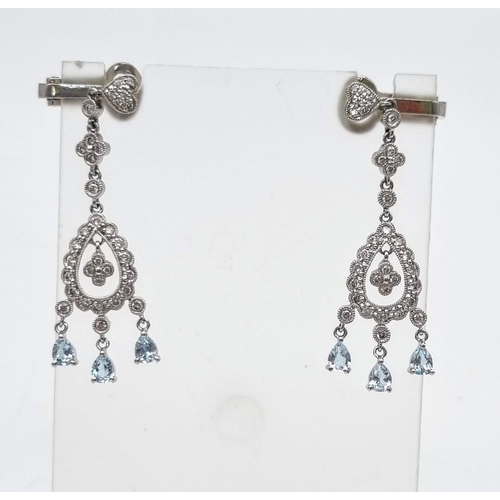 9 - A Beautiful Pair of 18K White Gold, Diamond and Topaz Drop Earrings. A drop diamond teardrop with th... 