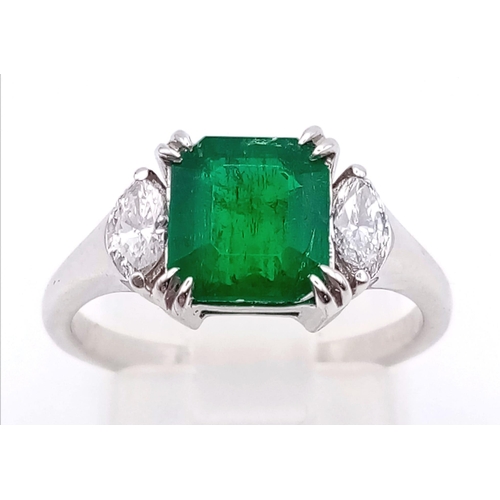 66 - An 18K White Gold, Emerald and Diamond Ring. Emerald-cut centre stone with a marquise cut diamond ei... 