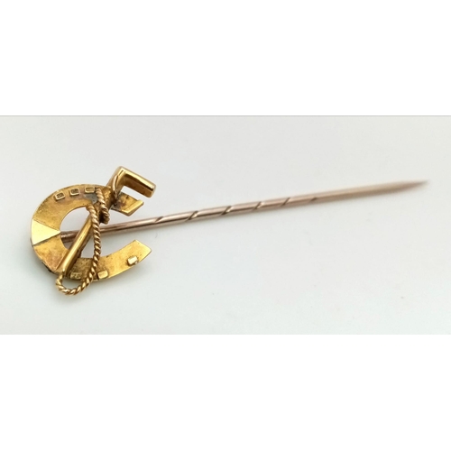 116 - A Victorian 15 carat yellow gold lapel pin in the shape of a horseshoe and ridding crop.