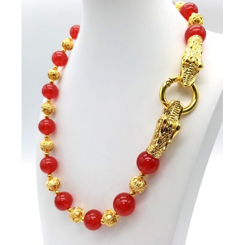 138 - A glamorous, Chinese, red jade, necklace and earrings set with 18 K yellow gold plated dragon clasp.... 