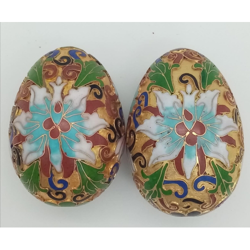 279 - Two very ornamental Chinese cloisonné eggs on wooden base. Height: 7 cm