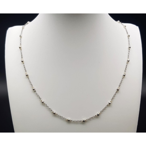 748 - An 18K White Gold and Seed Pearl Necklace with faceted barrel-shaped spacers. 3.6g total weight. 50c... 