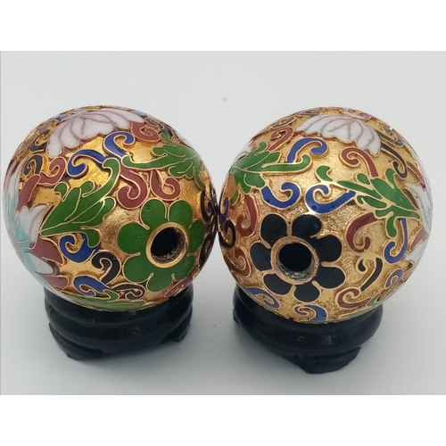 279 - Two very ornamental Chinese cloisonné eggs on wooden base. Height: 7 cm