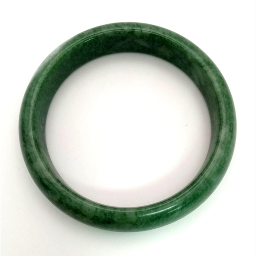 489 - A Green Jade Bangle. 6cm inner diameter.