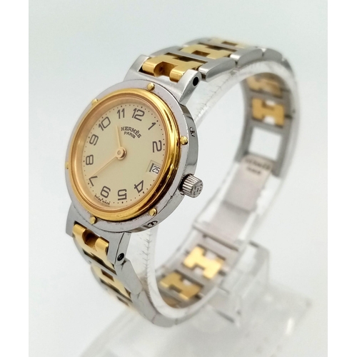 296 - A Hermes H Clipper Quartz Ladies Watch. Two tone strap and case - 24mm. Gold tone dial with date win... 