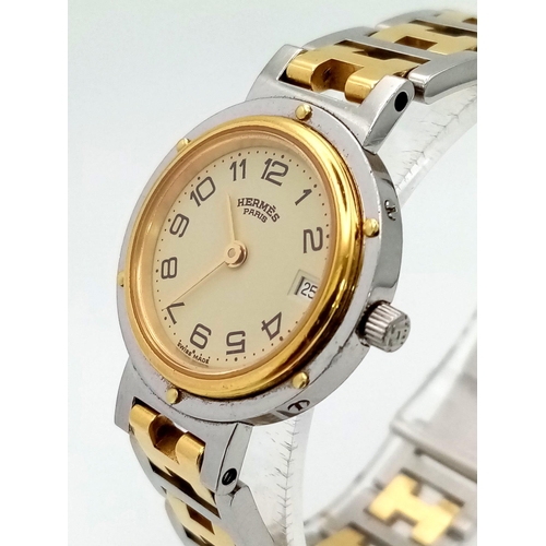 296 - A Hermes H Clipper Quartz Ladies Watch. Two tone strap and case - 24mm. Gold tone dial with date win... 