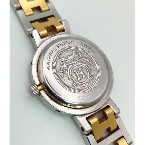 296 - A Hermes H Clipper Quartz Ladies Watch. Two tone strap and case - 24mm. Gold tone dial with date win... 