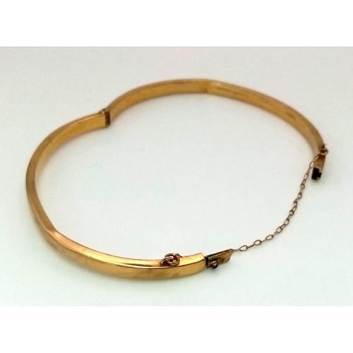 547 - A Vintage 9K Yellow Gold Bangle. 5.5cm. Clip opening and safety chain. 4.47g