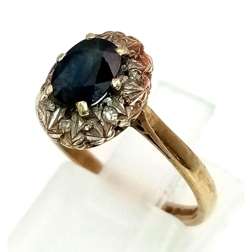 561 - A Vintage 9K Yellow Gold Sapphire and Diamond Ring. Central oval sapphire with a diamond surround. S... 