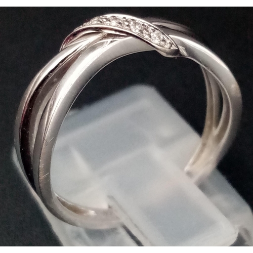 575 - A 9K White Gold Diamond Crossover Ring. Size M/N. 2.03g total weight.