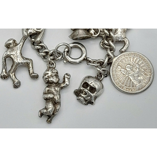 447 - A Vintage Silver Charm Bracelet. Over 20 charms. 72.43g total weight.