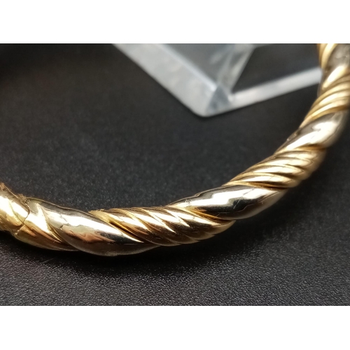 7 - A Classic Vintage 18K Yellow Gold Bangle. Geometric rope-twist decoration. Clip open clasp. 6cm inne... 