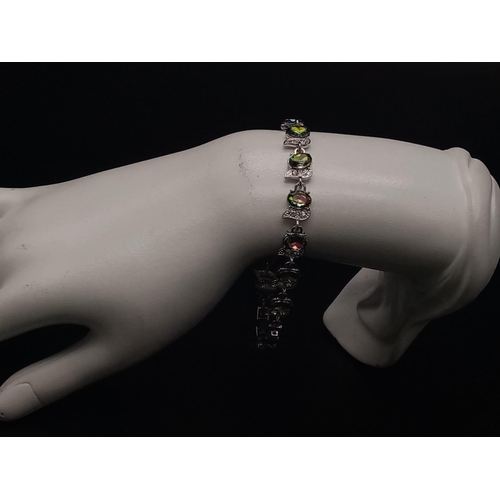 492 - A Mystic Topaz Tennis Bracelet. On white metal with white stone decoration. 20cm.