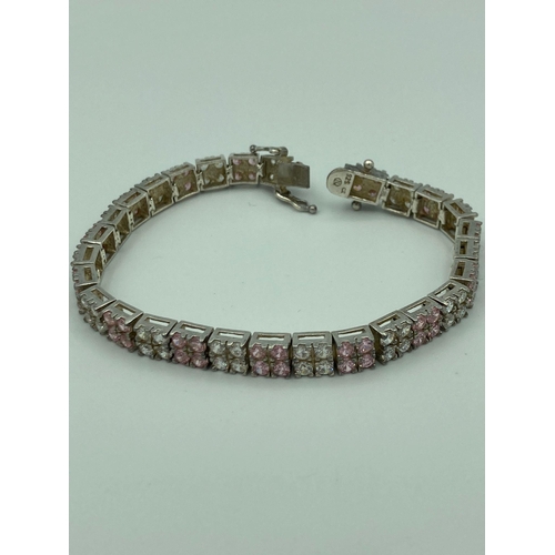 27 - Hallmarked SILVER TENNIS BRACELET, set with double lines of Sparkling Pink and White zirconias. 19 c... 