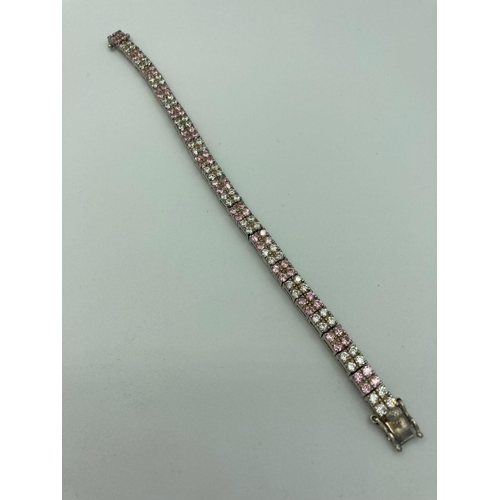 27 - Hallmarked SILVER TENNIS BRACELET, set with double lines of Sparkling Pink and White zirconias. 19 c... 