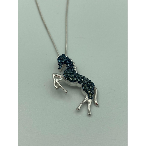 273 - SILVER HORSE PENDANT with blue gemstone detail mounted on a fine silver chain. Condition new and unw... 