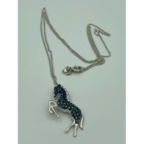 273 - SILVER HORSE PENDANT with blue gemstone detail mounted on a fine silver chain. Condition new and unw... 