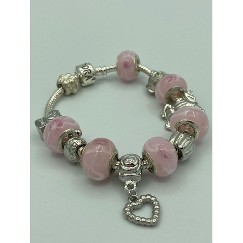 329 - Ladies BRACELET  with SILVER side pink charms together with unmarked charms and a 925 Silver clasp m... 