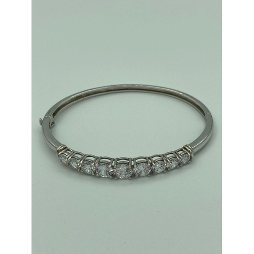 525 - Absolutely stunning SILVER BANGLE set to top with Shimmering zirconia gemstones. Markings inside ban... 