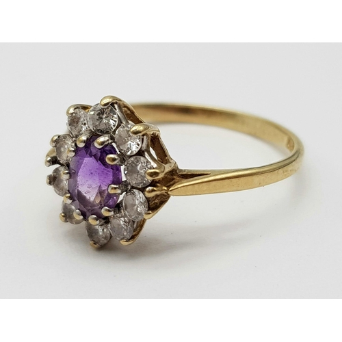 995 - A 9K Yellow Gold Amethyst Ring with White Stone Surround. 
Size K. 1.62g total weight.