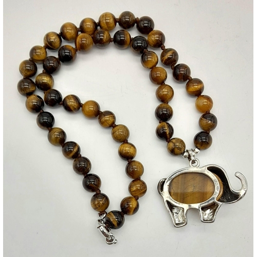 743 - A Tigers Eye Necklace with an Elephant Pendant. Pendant - 4cm. Necklace - 42cm. Beads - 8mm.