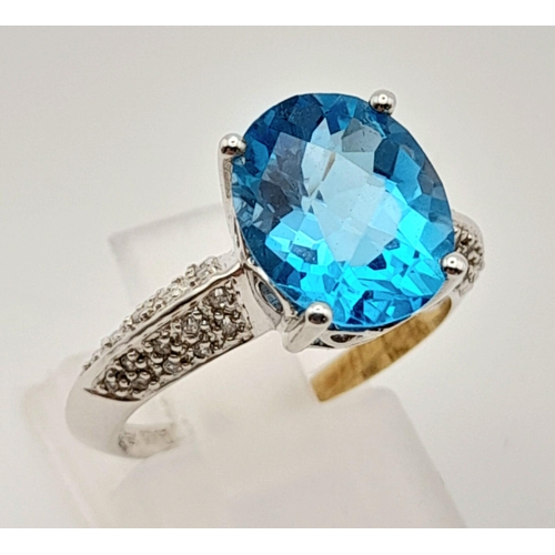 163 - A Mesmerising 18K White Gold Topaz and Diamond Ring. Central Ice-Blue Oval Cut Topaz with diamonds o... 