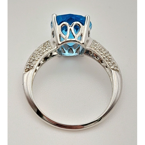 163 - A Mesmerising 18K White Gold Topaz and Diamond Ring. Central Ice-Blue Oval Cut Topaz with diamonds o... 