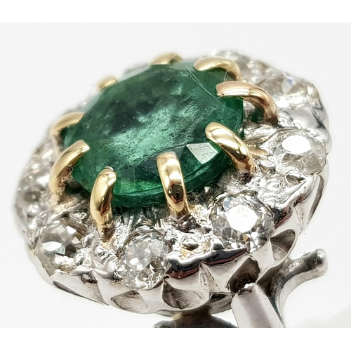 78 - An 18K White Gold (tested) Emerald and Diamond Ring. Central round cut emerald surrounded by a halo ... 