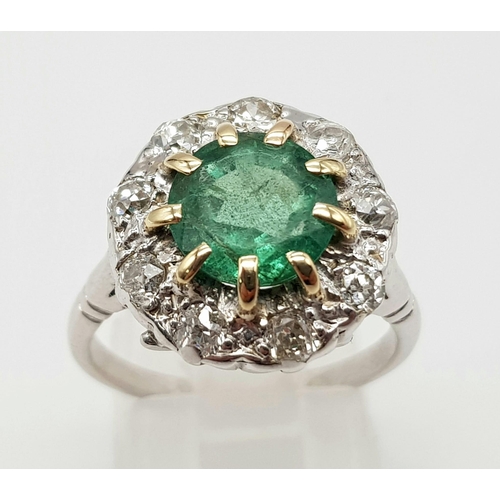 78 - An 18K White Gold (tested) Emerald and Diamond Ring. Central round cut emerald surrounded by a halo ... 