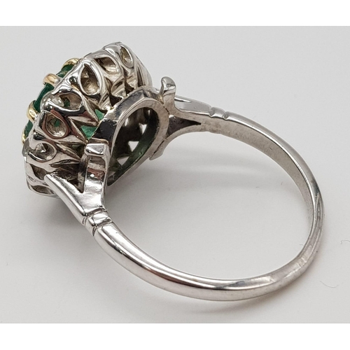 78 - An 18K White Gold (tested) Emerald and Diamond Ring. Central round cut emerald surrounded by a halo ... 