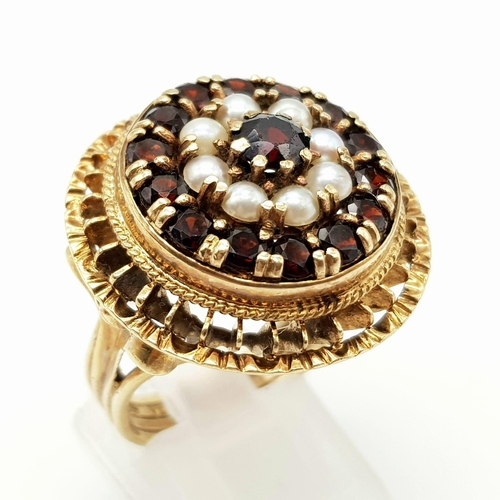 779 - A VINTAGE 9K GOLD REGAL RING WITH GARNETS AND SEED PEARLS.10.6gms   size O/P