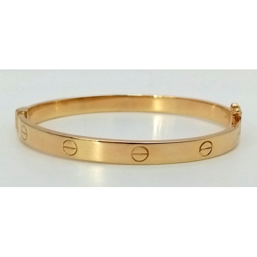 874 - A 9K Yellow Gold Cartier-Style Bangle. 6cm inner diameter. 8.5g.