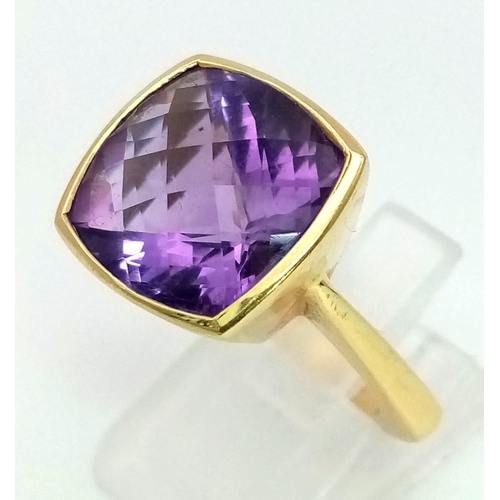 958 - A DESIGNER 18K GOLD RING WITH BEAUTIFULLY FACETED AMETHYST CENTRE STONE.  9.7gms  size I/J