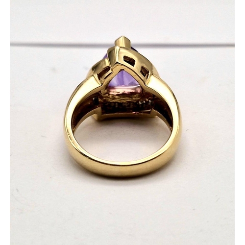 1192 - A 14K GOLD RING WITH LARGE TRIANGULAR AMETHYST CENTRE STONE SURROUNDED BY DIAMONDS.  11.9gms  size P