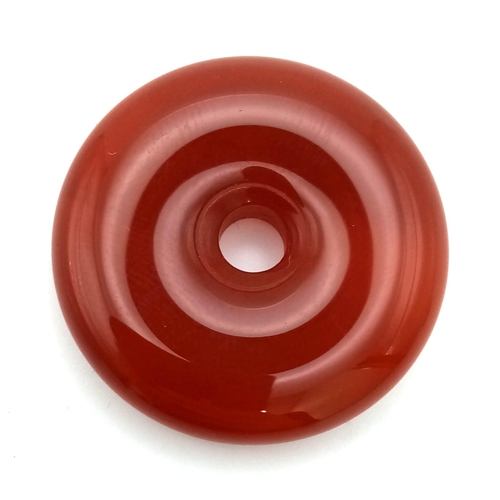 1478 - A Red Jade Doughnut Pendant. 30mm diameter.