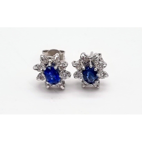 1299 - A Pair of 18K White Gold Sapphire and Diamond Stud Earrings. Oval cut sapphire with 8 round cut diam... 