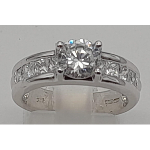 1422 - A 9K WHITE GOLD RING WITH SPARKLING ZIRCONIA STONES.  5.2gms   size M