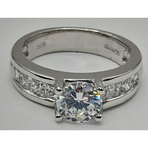 1422 - A 9K WHITE GOLD RING WITH SPARKLING ZIRCONIA STONES.  5.2gms   size M