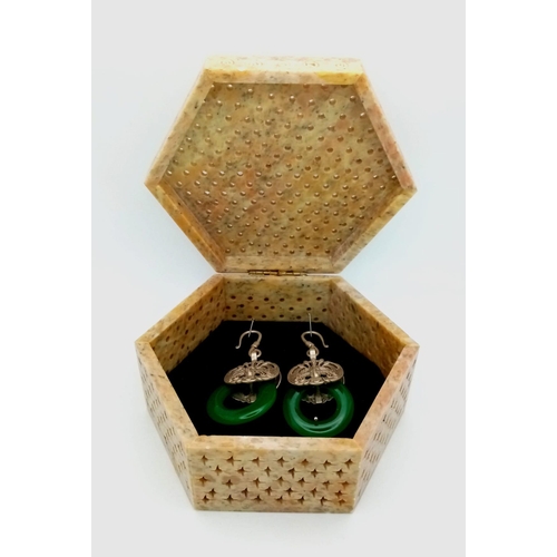 167 - An antique Chinese pair of silver earrings with green jade. Presented in a hand carved and pierced s... 