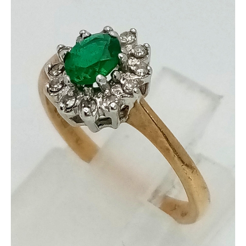 634 - A Vintage 9K Yellow Gold Emerald and Diamond Ring. Central oval emerald with a diamond surround. Siz... 