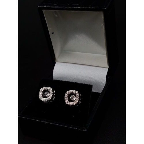 106 - A 10K white gold pair of diamond earrings with moving parts. made in USA with original box.