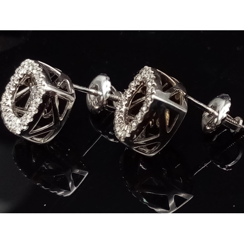 106 - A 10K white gold pair of diamond earrings with moving parts. made in USA with original box.